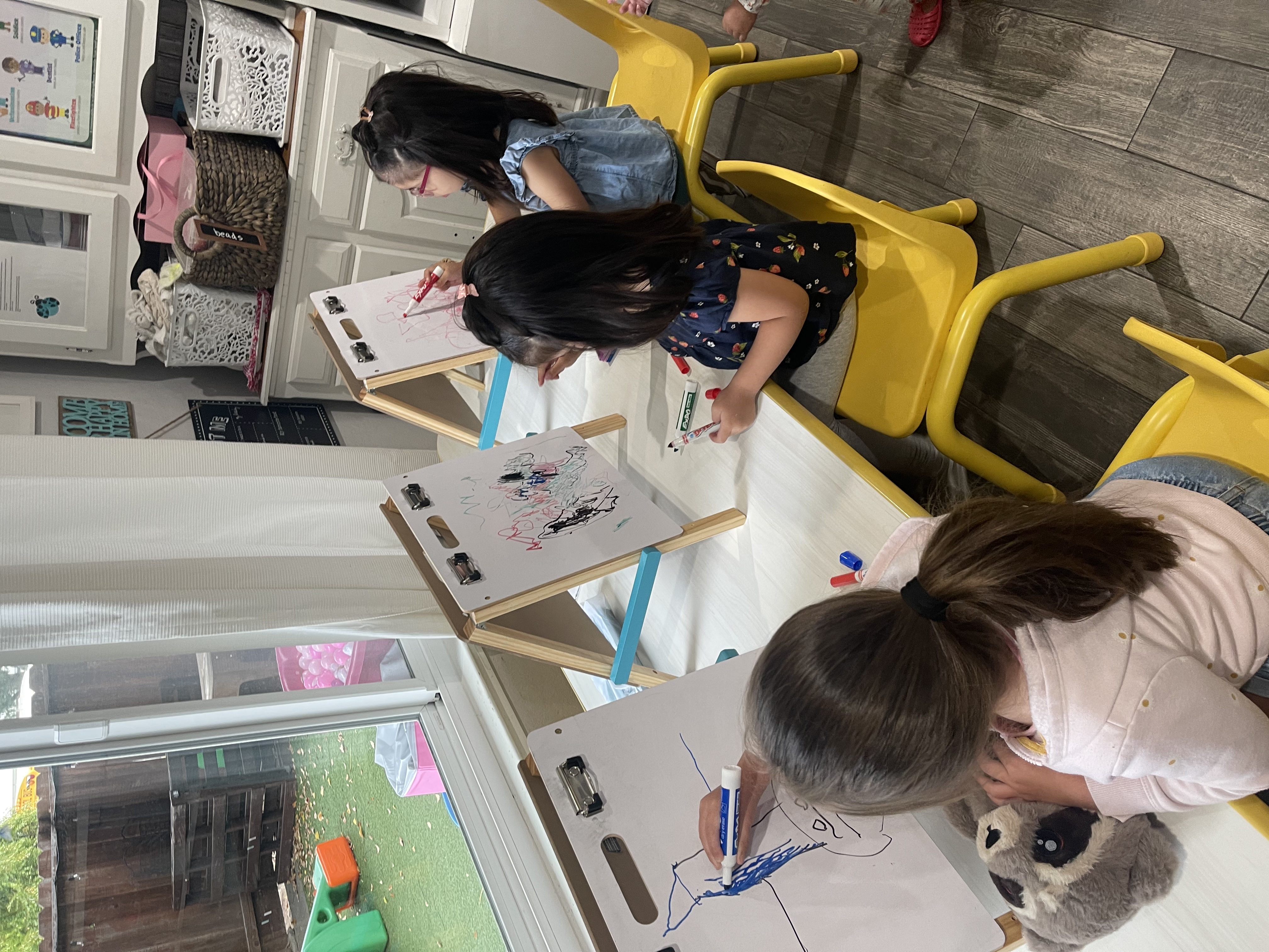 Children drawing on easels during an art activity